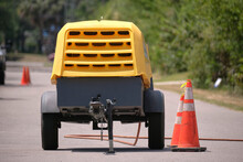 Yellow Jackhammer Machine With Compressor Trailer On Road Construction Site