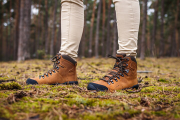 Wall Mural - tourist with hiking boots standing in forest. waterproof leather ankle boot