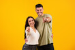 © Prostock-studio - Cheerful young arabic woman and man in casual hugging showing fingers to camera