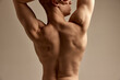 Cropped image of muscular, relief male shirtless body over grey studio background. Strong, healthy back. Concept of men's health and beauty, body and skin care, fitness, youth. Body art