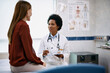 © Drazen - Black female doctor talking to woman during medical appointment in hospital.