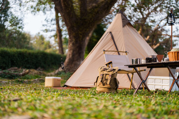 outdoor camping table set with nature beside tent campsite. travel and camping concept