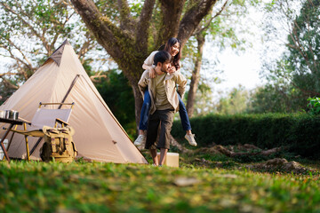 asian couple camping outdoors. young couple tourists spending time together on nature beside tent ca