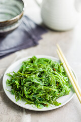 Wall Mural - Green seaweed. Japanese wakame salad on plate.