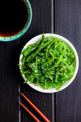 Sticker - Green seaweed. Japanese wakame salad and soy sauce. Top view.