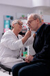 © DC Studio - Pharmacy employee checking old man ear with otoscope and examining for infection. Elderly patient getting otoscopy consultation from pharmaceutical specialist in drugstore