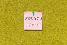 "Are You Happy?" Question On Pink Post-it Paper With Cork Board Background. This Question Can Be Used For Business Concept To Ask People In Order To Provide Any Service To Them.