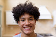 © Wavebreak Media - Portrait of smiling biracial man with curly hair in kitchen at home
