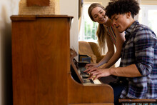 Happy Diverse Couple Having Fun Playing Piano Together At Home, Copy Space