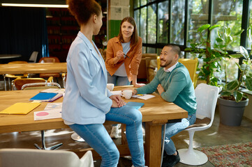 Busy multiracial office employees working in coworking shared room