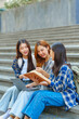 © NanSan - Attractive asian college student using laptop and tablet studying with group of friends together with english language classroom, social media and education concept.