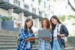 © NanSan - Attractive asian college student using laptop and tablet studying with group of friends together with english language classroom, social media and education concept.