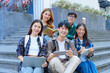 © NanSan - Attractive asian college student using laptop and tablet studying with group of friends together with english language classroom, social media and education concept.