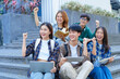 © NanSan - Attractive asian college student using laptop and tablet studying with group of friends together with english language classroom, social media and education concept.