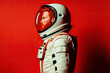 Portrait of red-haired man with beard, wearing white astronaut suit and helmet, on red background. Image created with Artificial Intelligence.