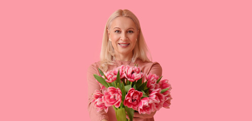 Poster - Mature woman with bouquet of beautiful tulips on pink background. International Women's Day