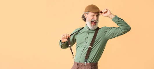 Canvas Print - Cool senior man with suspenders on beige background