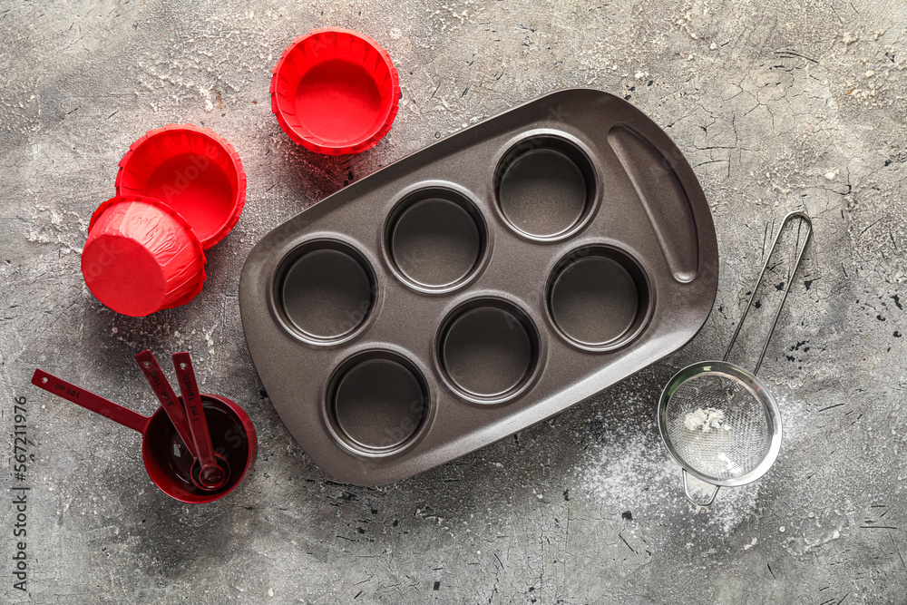 Set of utensils for preparing muffins on grunge background