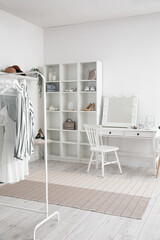 Sticker - Interior of stylish dressing room with table, shelving unit and clothes