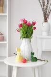 Fototapeta Kawa jest smaczna - Vase with tulips, Easter eggs and rabbits on table in living room