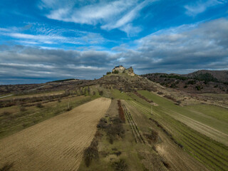 Wall Mural - Aerial view of partially restored Boldogko, medieval Gothic castle in Borsod county Hungary with round gate tower, donjon cloudy blue sky background