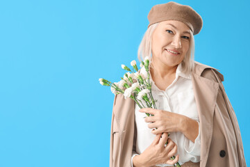 Wall Mural - Beautiful mature woman with bouquet of flowers on light blue background