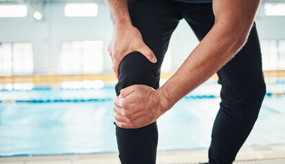 Wall Mural - Hands, knee injury and swimming instructor holding his joint in pain with a pool in the background of a gym. Fitness, coach and anatomy with a sports man suffering from a sore leg during exercise