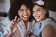 © S Fanti/peopleimages.com - Friends, selfie and smile, women on bed in pajamas with bonding, peace sign and happy face. Social media, girl and influencer in portrait picture, sharing memory and friendship at bedroom sleepover.