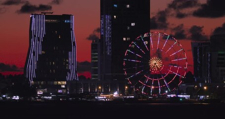 Wall Mural - Batumi, Adjara, Georgia. View From Sea Beach To Cityscape With Modern Urban Architecture, Skyscrapers, Ferris Wheel In Bright Evening Colors. Night City Light Illumination.