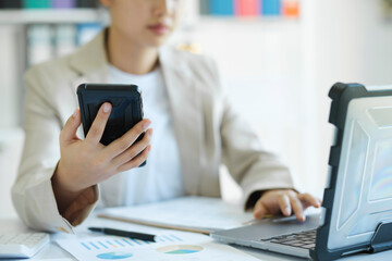 -.Close up young Asian businesswoman is working at office using mobile phone.