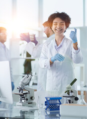 Smiling scientists looking at camera arms crossed in laboratory