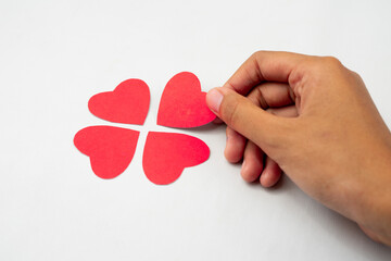 Poster - Hand completing heart puzzle forming clover