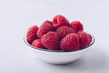 Wall Mural - Raspberry. Fresh organic juicy raspberries in white bowl close-up