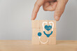 © Ratana21 - For world health day, health check up and insurance, wellness, wellbeing concept. Hand complete wooden cube block with stethoscope and heart icon