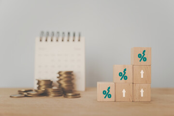 Wall Mural - For business and finance concept increasing percentage on wooden cube block and blurred stack of coins and white calendar