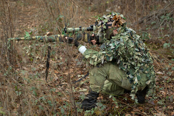 Wall Mural - Sniper aiming from his rifle in forest.