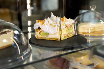 A showcase with sweets in a cafe. Cupcakes and colorful macaroons on the cake stand.