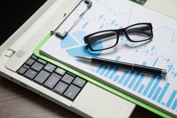 Sticker - Pen, eyeglasses, graphs on the computer keyboard.