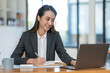 © crizzystudio - Asian businesswoman clicking details on laptop computer analyzing data checking accuracy of financial income happily in office management concept management.