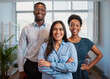 © Meeko Media - Group of smiling business people pose arms folded in office, diverse trio