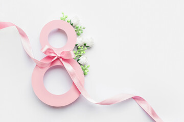 pink paper cut eight with ribbon on white background. postcard march 8 concept