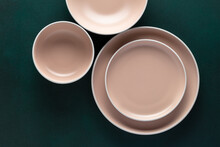 Three Empty Beige Plates On A Dark Green Table, Grunge Background. Top View. Card Or Menu Template, Flat Lay, Minimalistic Design. Tableware, Crockery. Copy Space. Clean Dishes Above.