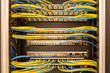 Front view on neat and tidily patched network cables, RJ45, connected to the switches and routers mounted on the rack in data centre, networking