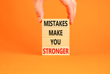 Wall Mural - Mistake make stronger symbol. Concept words Mistakes make you stronger on wooden blocks. Beautiful orange background. Businessman hand. Business mistake make stronger concept. Copy space.
