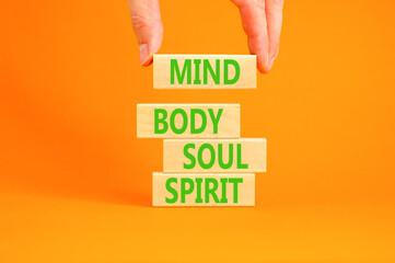 Mind body soul spirit symbol. Concept words Mind Body Soul Spirit on wooden blocks. Beautiful orange table orange background. Businessman hand. Lifestyle mind body soul spirit concept. Copy space.