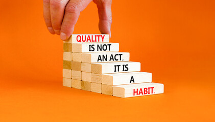 Wall Mural - Quality is a habit symbol. Concept words Quality is not an act it is a habit on wooden blocks. Beautiful orange table orange background. Businessman hand. Business quality is habit concept. Copy space