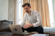 © Miljan Živković - One man adult Caucasian male work on laptop computer from hotel room