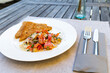 The image shows a light summer fish salad served on a rustic wooden table
