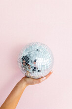 Hand Holding Disco Ball On Light Pink Background