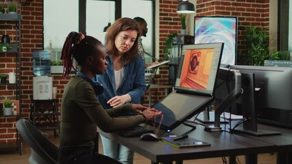 Poster - Diverse colleagues analyzing game developing electronics and new production interface in creative agency office. Artistic engineer talking to coworker about professional software creation.